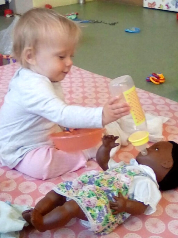 Baby playing with doll